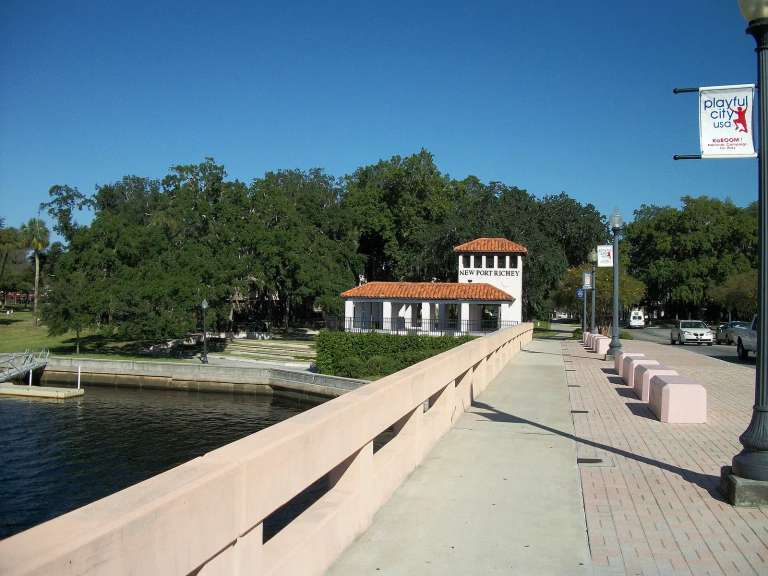 El puente de Main Street sobre el río Pithlachascotee, con la torre blanca de New Port Richey y su techo de tejas al fondo