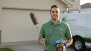 HVAC technician holds diagnostic tools in front of service van and residential garage.